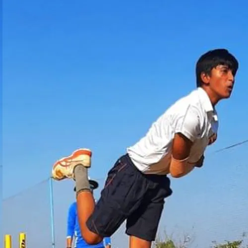 A bowler in delivery stride during a clinic drill