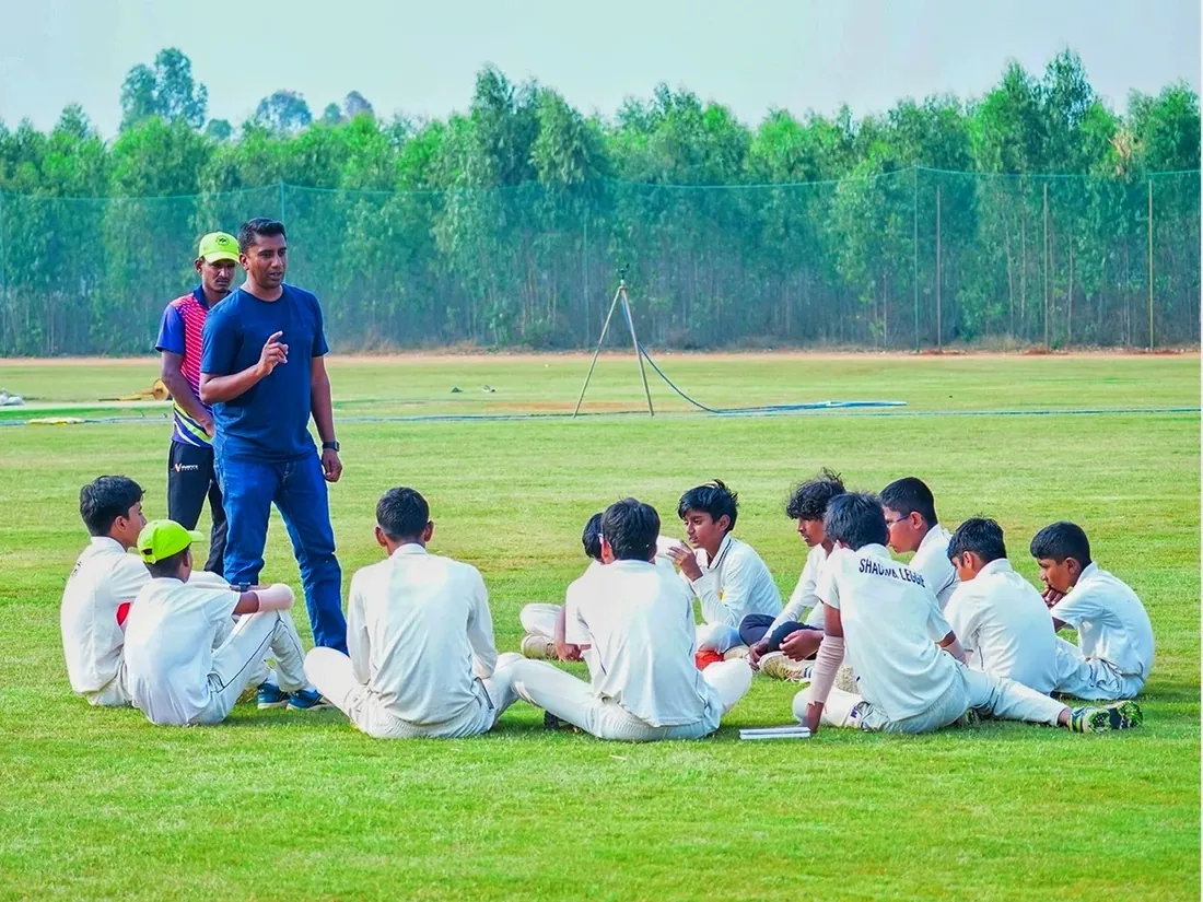 A coach talking with a group of young players on the ground at Kreeda Kshetra