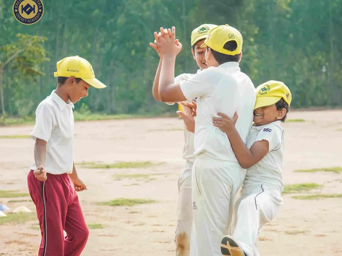 Young players celebrating at the practice nets